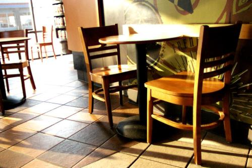 Photo of a coffee shop which is fairly empty, with a few two seater tables freed up, from soopahtoe of FreeImages.com