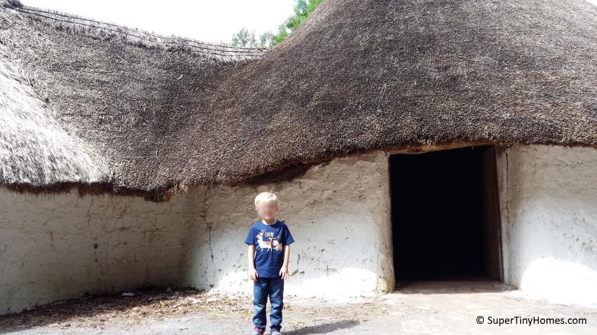 A traditional Stone Age house with mudbrick walls and a thatched roof.