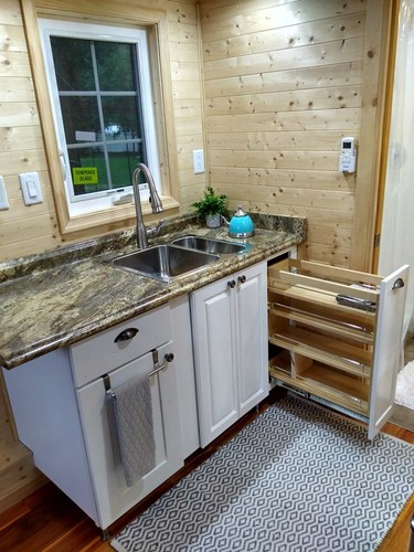 The kitchen area with pull-out storage being shown, and also the sink.