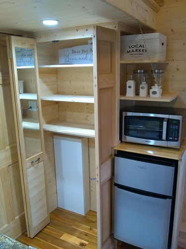 The fridge/freezer, pantry area (with door open) and microwave.