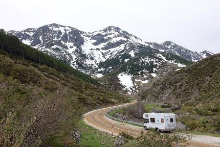 An RV driving along an empty mountain road, from MemoryCatcher of pixabay.