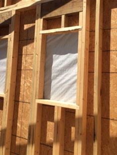 Photo of wall framing with a window towards the top, and cripples underneath for support, from Less Everything.